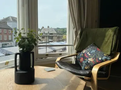 a living room with a chair and a table and a window at The Nook Castle Street Ludlow in Ludlow