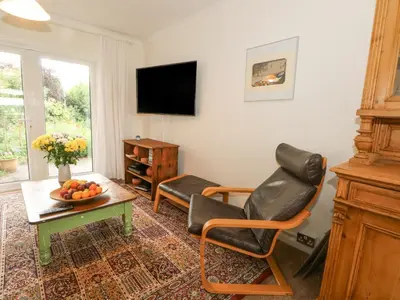 a living room with two chairs and a television at Plum Hill in Oswestry