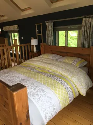 a bed with a wooden headboard and pillows in a bedroom at A Tranquil Retreat for Two in Pont-Robert