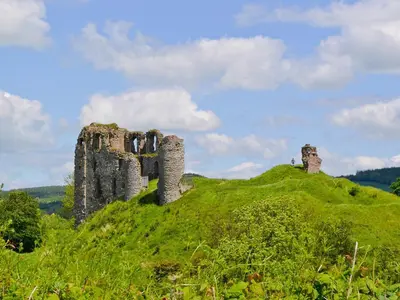 a castle on top of a green hill at Oak View Cottage in Llangunllo