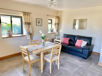 a living room with a table and a couch at Oak View Cottage in Llangunllo