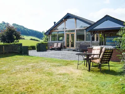 a house with a table and chairs in the yard at Heyope Cottage in Llangunllo