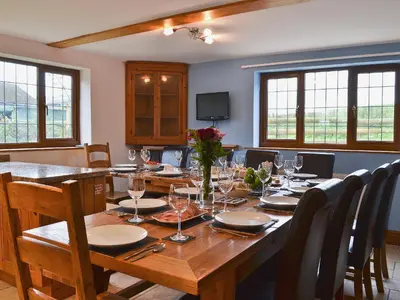 a dining room with a long wooden table and chairs at Celyn in Montgomery