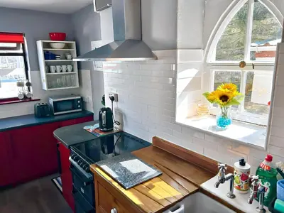 a kitchen with a stove and a window and a sink at The Rope and Anchor Aberaeron in Aberaeron