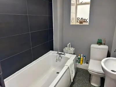 a bathroom with a white bath tub next to a toilet at The Rope and Anchor Aberaeron in Aberaeron
