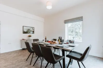 a white dining room with a table and chairs at Tedsmore Cottages in Oswestry