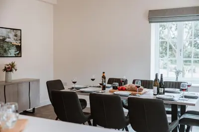 a dining room with a table with chairs and wine bottles at Tedsmore Cottages in Oswestry