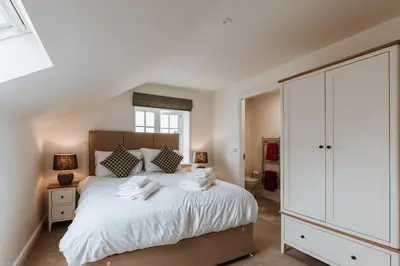 a bedroom with a white bed with towels on it at Tedsmore Cottages in Oswestry