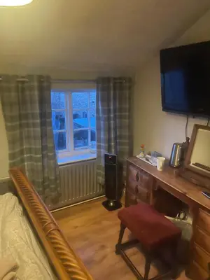 a bedroom with a bed and a desk and a television at Dolphin Inn in Llanymynech
