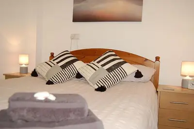 a bedroom with a bed with black and white pillows at No 6 at Dolgoch Falls Cottages in Bryn-crug