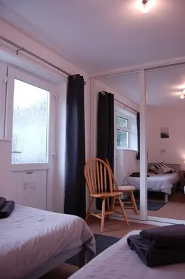 a bedroom with a mirror and a chair and a bed at No 6 at Dolgoch Falls Cottages in Bryn-crug