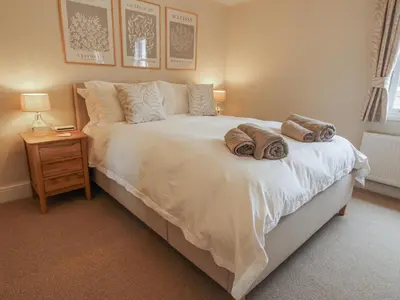 a bedroom with a large white bed with towels on it at Riverbank in Shrewsbury