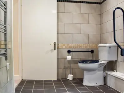 a bathroom with a toilet with a blue seat at The Dairy - Uk47471 in Llanerch-Aeron