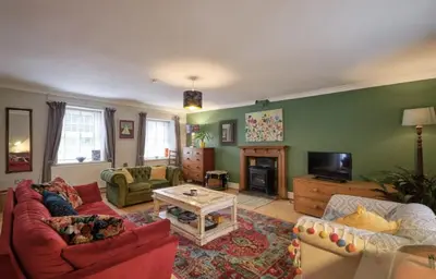 a living room with a couch and a table at Drws Y Coed in Tal-gareg