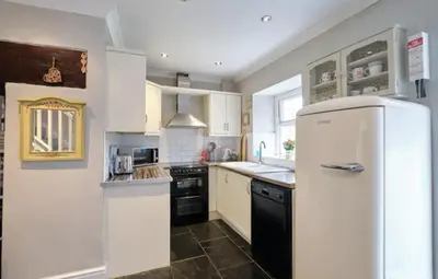 a kitchen with a white refrigerator and a sink at Drws Y Coed in Tal-gareg