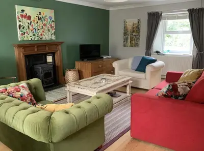 a living room with a couch and a coffee table at Drws Y Coed in Tal-gareg