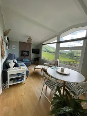 a living room with a couch and a table at Cosy private Chalet in Tywyn