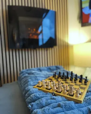 a chess board on top of a bed with a television at Cosy private Chalet in Tywyn