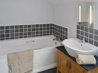 a bathroom with a white tub and a sink at The Granary - Or3 in Henfynyw Upper
