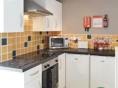 a kitchen with white cabinets and a microwave at The Cow Shed - Or5 in Henfynyw Upper