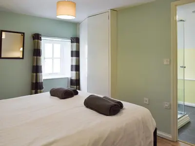 a bedroom with a bed with two pillows on it at The Cow Shed - Or5 in Henfynyw Upper