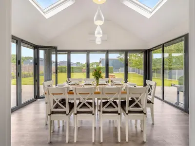 a dining room with a table and chairs and large windows at Orchard Barns - Uk47200 in Stapleton