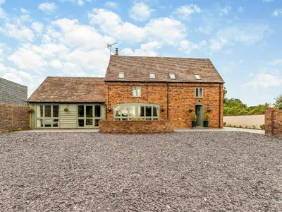 a brick house on a gravel driveway at Orchard Barns - Uk47200 in Stapleton