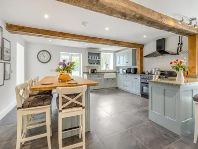 a kitchen with blue cabinets and a wooden table at Orchard Barns - Uk47200 in Stapleton