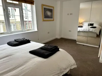 a bedroom with a bed with two black towels on it at Penny Black Apartment, Kington in Kington