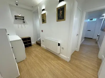 a room with a hallway with white walls and wooden floors at Penny Black Apartment, Kington in Kington