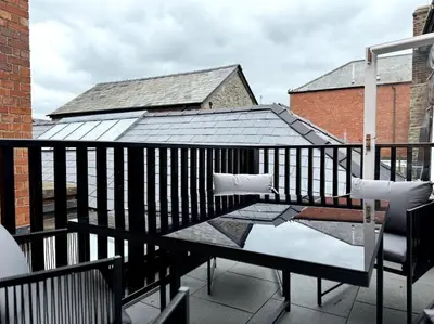 a balcony with a table and chairs and a roof at Penny Black Apartment, Kington in Kington