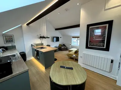 a kitchen and living room with a table in a room at Penny Red apartment in Kington in Kington