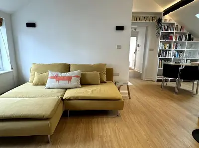 a living room with a couch with two pillows on it at Penny Red apartment in Kington in Kington