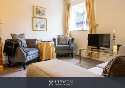 a living room with two chairs and a television at 2 Bed Shrewsbury Apartment in Great Location in Shrewsbury