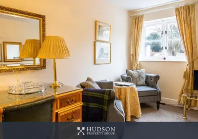 a living room with a chair and a mirror at 2 Bed Shrewsbury Apartment in Great Location in Shrewsbury