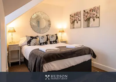 a bedroom with a bed with a mirror on the wall at 2 Bed Shrewsbury Apartment in Great Location in Shrewsbury
