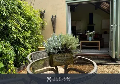 a garden bench with a potted plant on it at Beautiful Cottage in the Heart of Shrewsbury in Shrewsbury