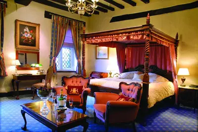 a bedroom with a bed and a table and chairs at Albright Hussey Manor in Shrewsbury