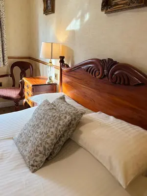 a bed with a wooden headboard and a pillow on it at Albright Hussey Manor in Shrewsbury