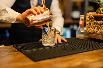 a person pouring a drink into a glass at Albrighton Hall Hotel and Spa, a member of Radisson Individuals in Shrewsbury