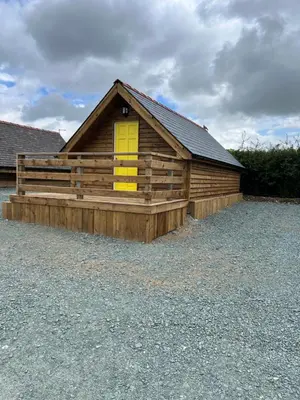 a log cabin with a yellow door and a yellow window at Weston glamping pod in Oswestry