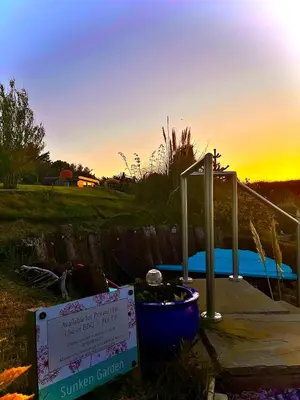 a sign next to a swimming pool at sunset at Sea Breeze Lodge in Aberaeron