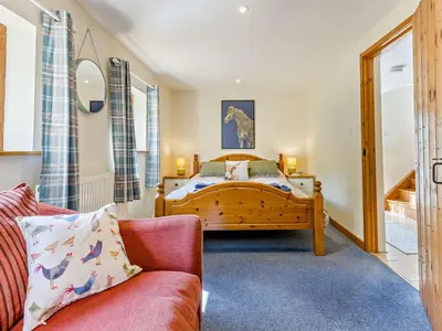 a bedroom with a bed and a red couch at 5 Bed in Craven Arms oc-95212 in Tugford