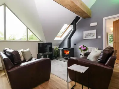 a living room with a couch and a fireplace at The Coach House in Ludlow