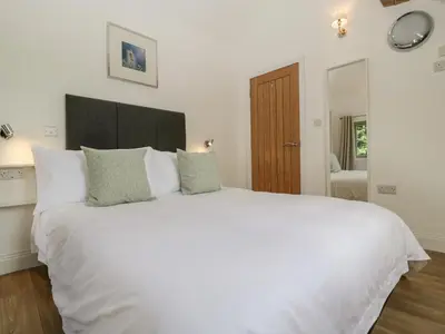 a bedroom with a large white bed with white pillows at The Coach House in Ludlow