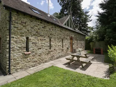 a picnic table in front of a brick building at The Coach House in Ludlow