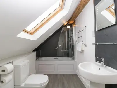 a bathroom with a white toilet and a sink at The Coach House in Ludlow