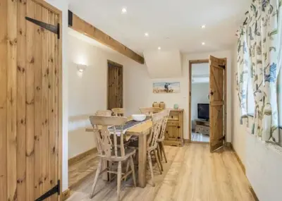 a dining room with a wooden table and chairs at Frondeg Bach in Tregaron