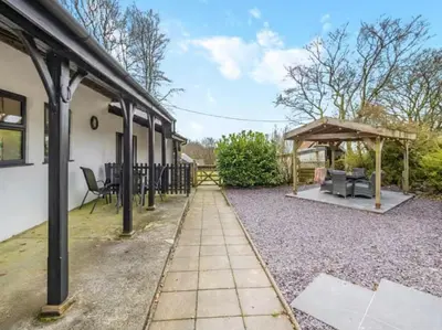 a patio with a gazebo next to a house at Frondeg Bach in Tregaron