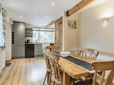 a kitchen and dining room with a wooden table and chairs at Frondeg Bach in Tregaron